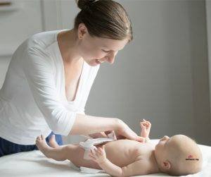Featured image of smiling mother changing baby diaper