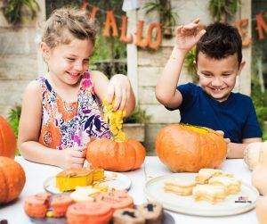 Featured image of two children at table with food playing with pumpkins
