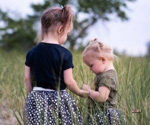 Featured image of two little girls standing in grass field