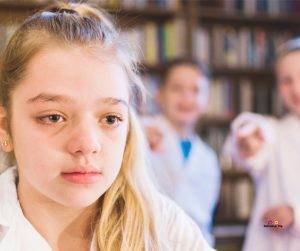 Featured image of crying girl in white being bullied