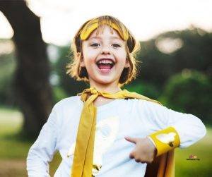 Featured image of smiling girl in white and yellow superhero costume